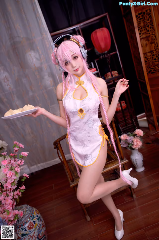 A woman in a pink dress holding a plate of food.