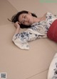 A woman laying on the floor with her head on a pillow.