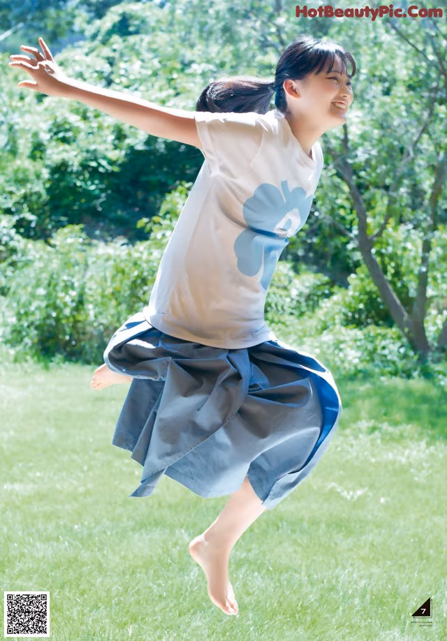 A young girl is jumping in the air in a park.