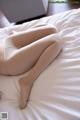 A woman laying on top of a white bed.