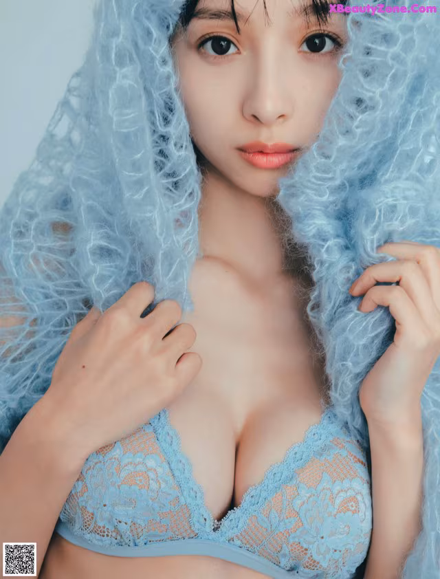 A woman wearing a blue bra and a blue hood.