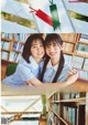 A couple of young women hugging each other in front of bookshelves.