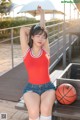 A woman sitting on a bench with a basketball.