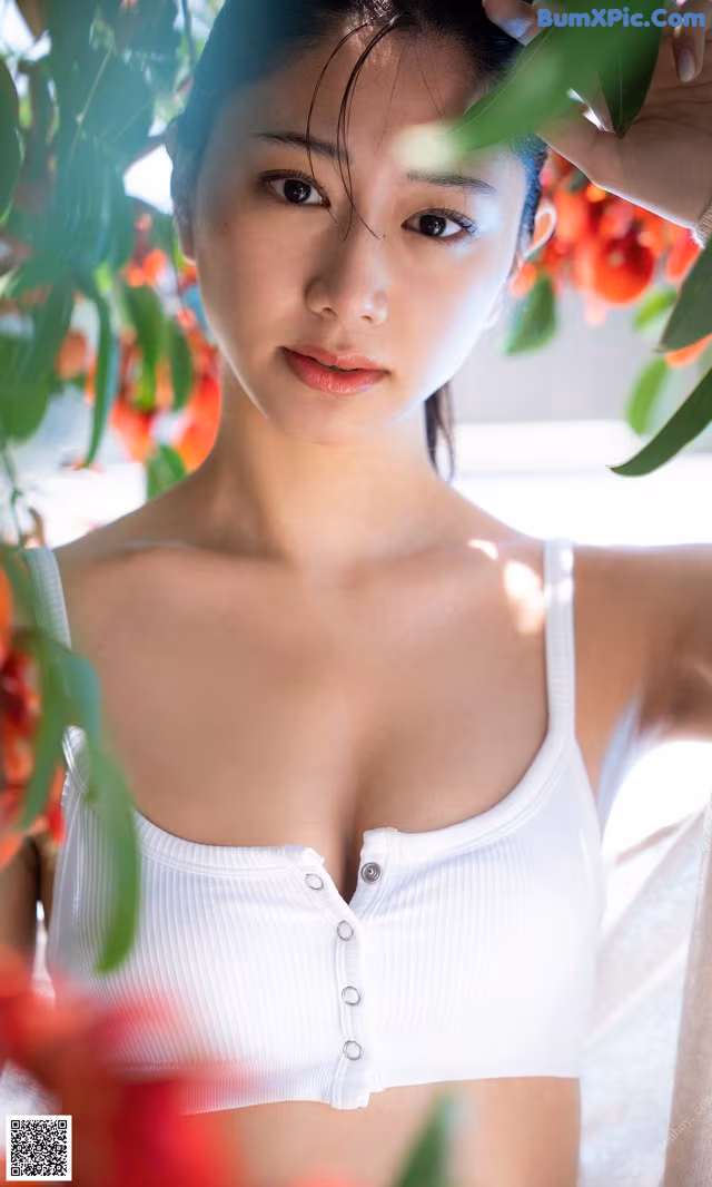 A woman in a white bra top posing for a picture.