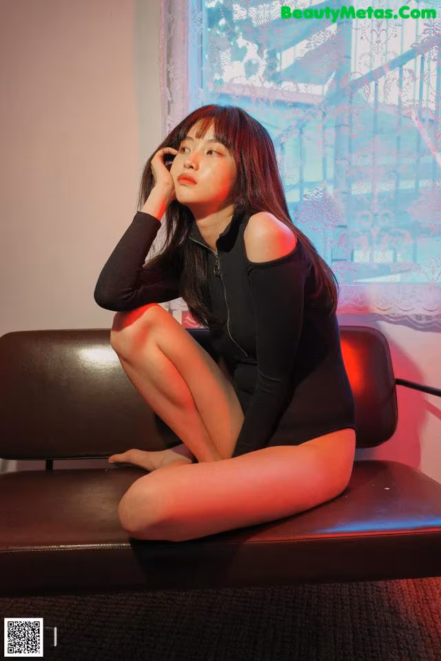 A woman sitting on a couch talking on a cell phone.