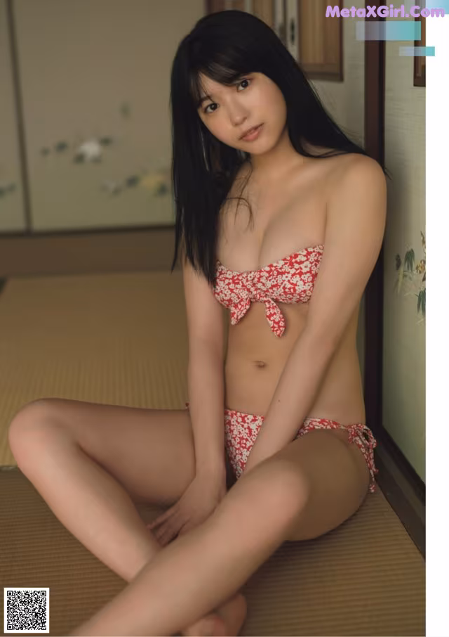 A woman in a red and white bikini sitting on the floor.